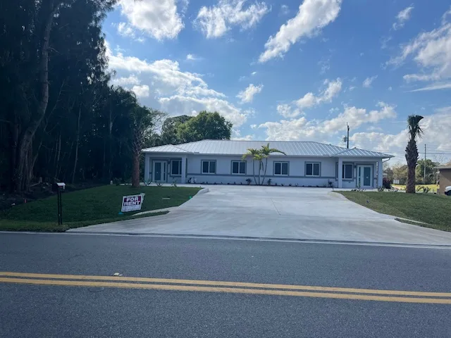 Completed home viewed from the street with new concrete driveway